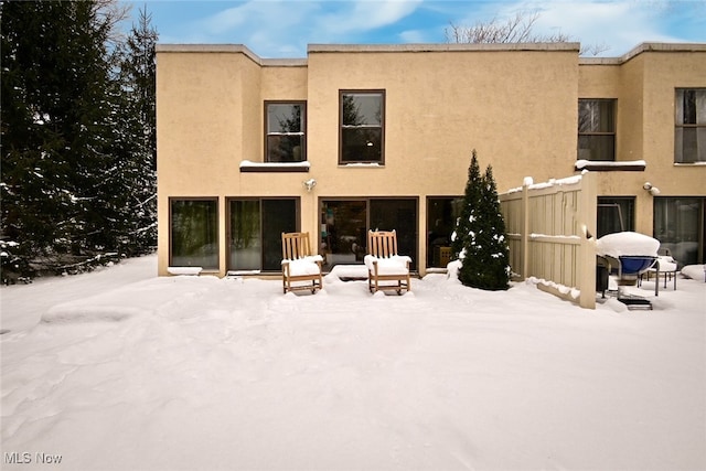 view of snow covered back of property