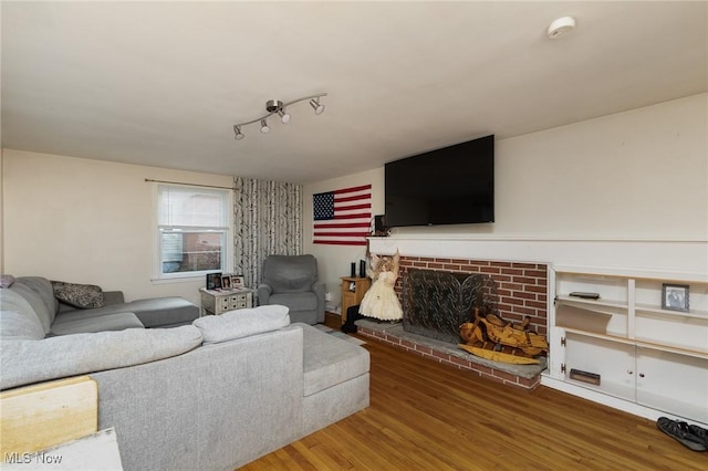 living room with a fireplace, hardwood / wood-style floors, and track lighting