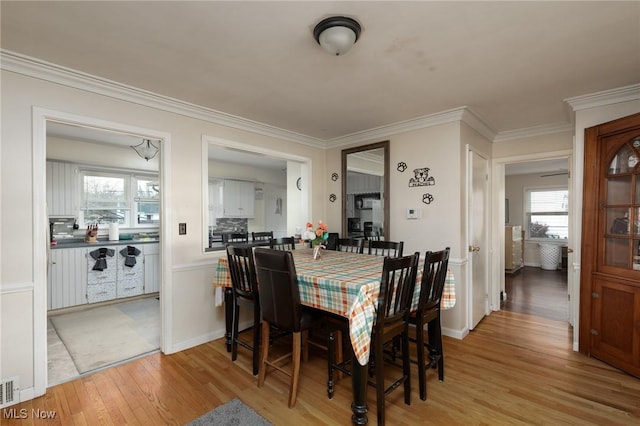 dining room featuring light hardwood / wood-style floors and ornamental molding