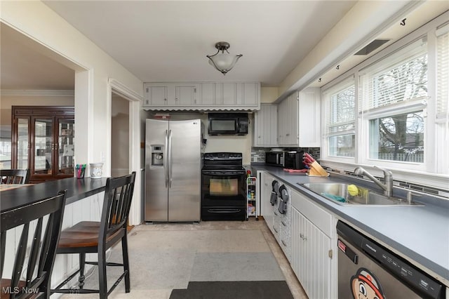 kitchen featuring black appliances, white cabinets, crown molding, sink, and tasteful backsplash