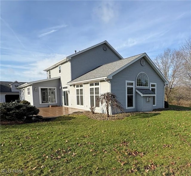 back of house featuring a lawn and a patio