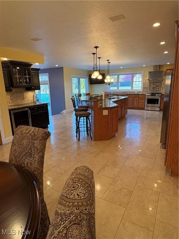 kitchen with appliances with stainless steel finishes, backsplash, a kitchen breakfast bar, a kitchen island with sink, and sink