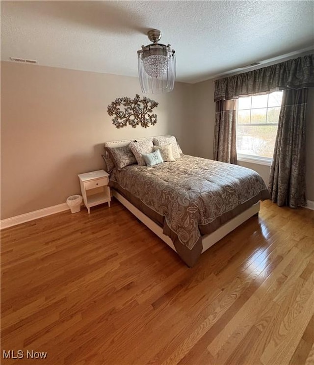 bedroom featuring wood-type flooring and a textured ceiling