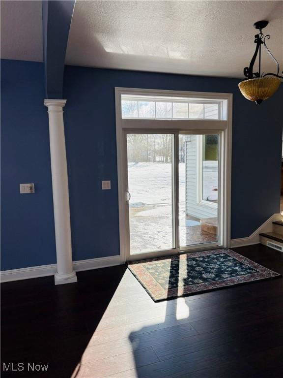 entrance foyer with a textured ceiling and dark hardwood / wood-style floors