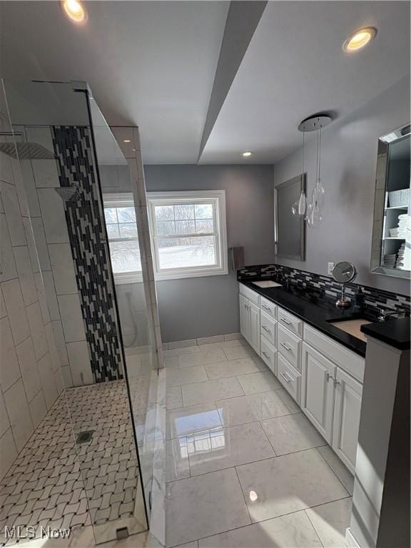 bathroom with vanity and tiled shower