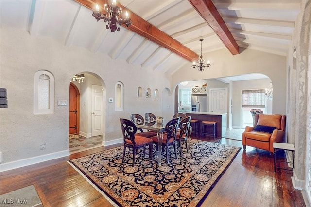 dining room featuring vaulted ceiling with beams, dark hardwood / wood-style flooring, and an inviting chandelier