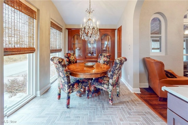 dining room with vaulted ceiling and a chandelier