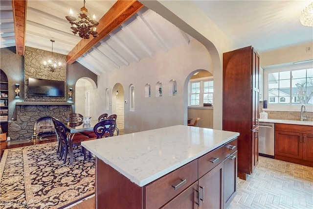 kitchen with dishwasher, lofted ceiling with beams, a stone fireplace, and hanging light fixtures