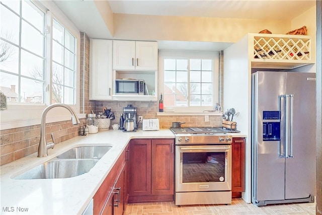 kitchen with backsplash, high end appliances, and sink