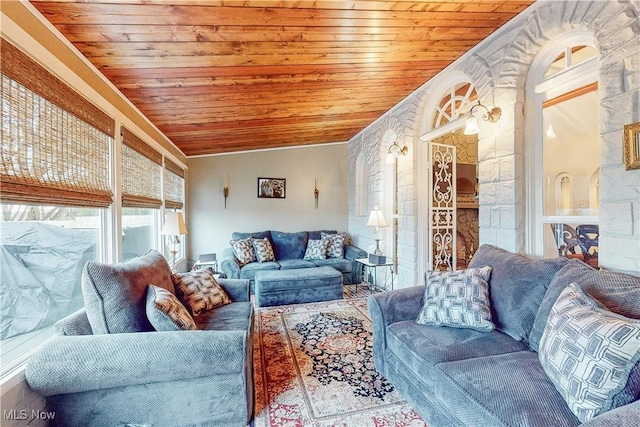 living room featuring vaulted ceiling, wooden ceiling, and crown molding