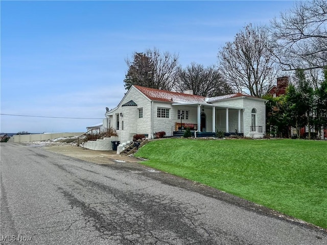 view of front of house featuring covered porch and a front yard