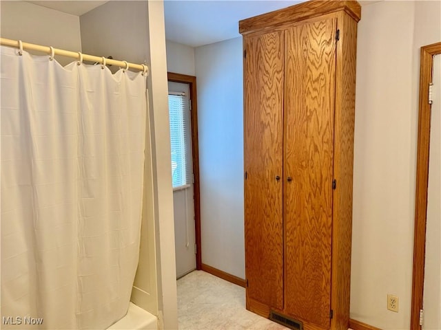 bathroom with shower / bath combination with curtain