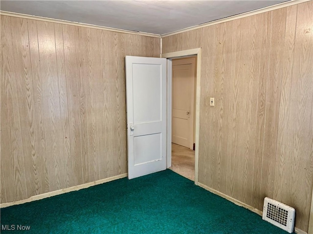 spare room with dark carpet and wooden walls