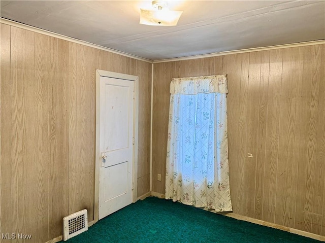 unfurnished room featuring dark carpet and wooden walls