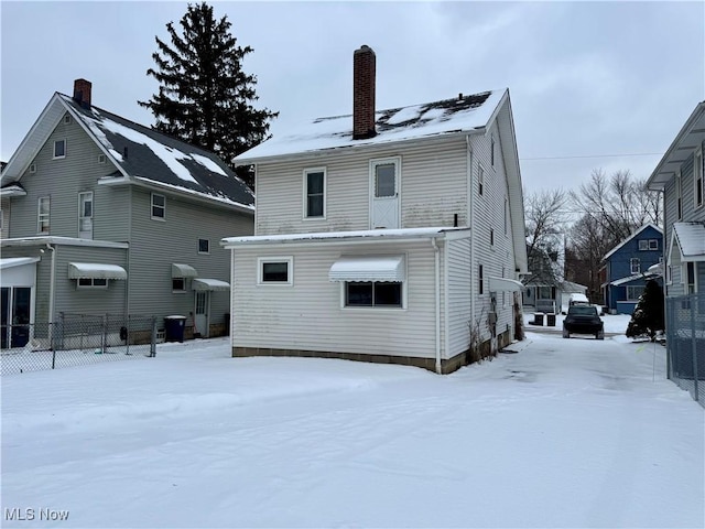 view of snow covered back of property