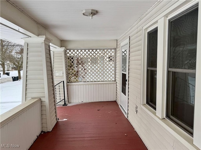 snow covered deck featuring a porch