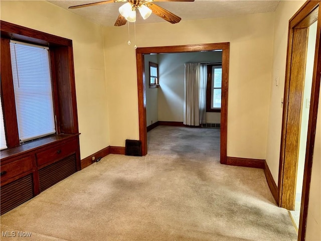 carpeted spare room with ceiling fan