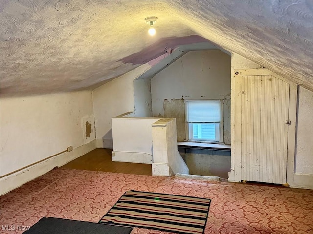 bonus room featuring a textured ceiling and vaulted ceiling