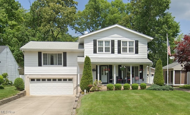 view of front of home featuring a porch, a front lawn, and a garage