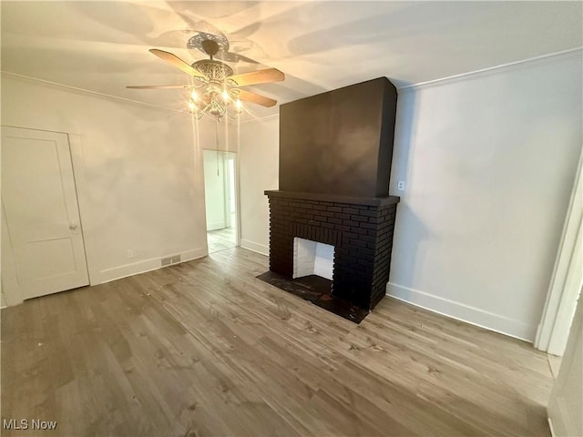 living room with light wood-type flooring, ceiling fan, and crown molding