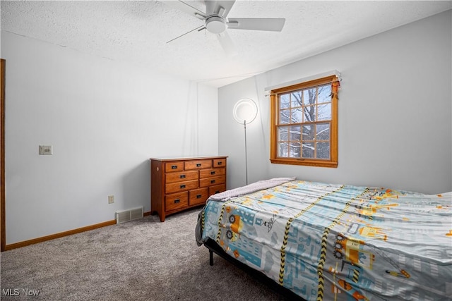 carpeted bedroom with ceiling fan and a textured ceiling