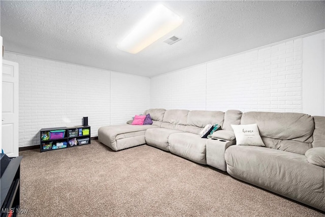 carpeted living room with visible vents, brick wall, and a textured ceiling