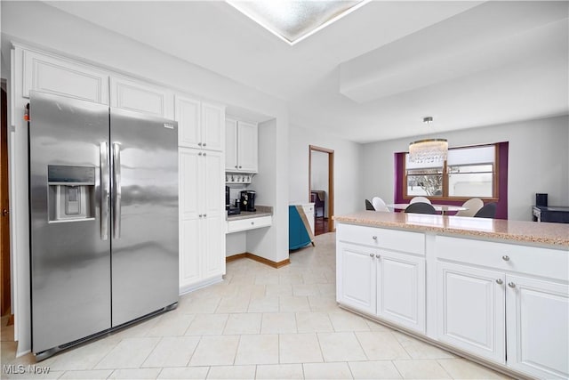 kitchen featuring stainless steel refrigerator with ice dispenser, white cabinetry, and hanging light fixtures