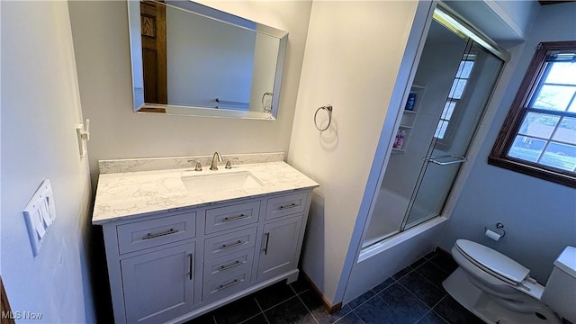 bathroom featuring baseboards, bath / shower combo with glass door, toilet, tile patterned floors, and vanity