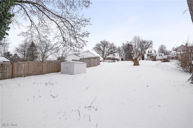 yard covered in snow with a shed