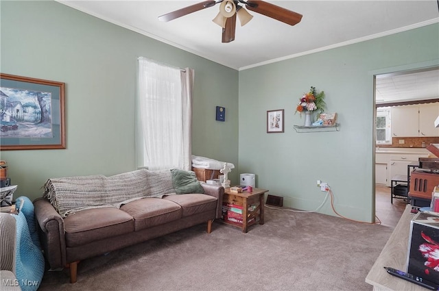 living room featuring ceiling fan, crown molding, and light carpet