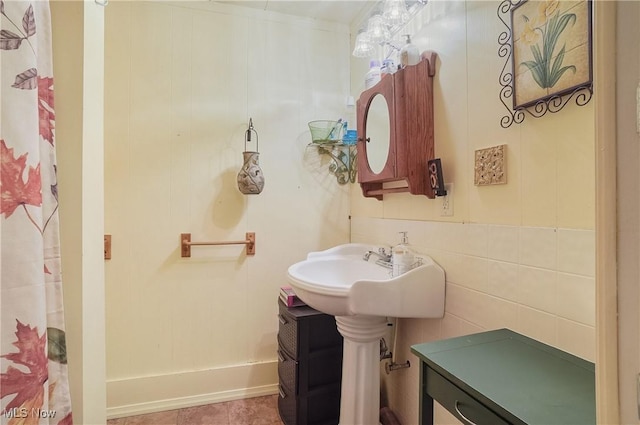 bathroom featuring tile patterned floors, curtained shower, and tile walls