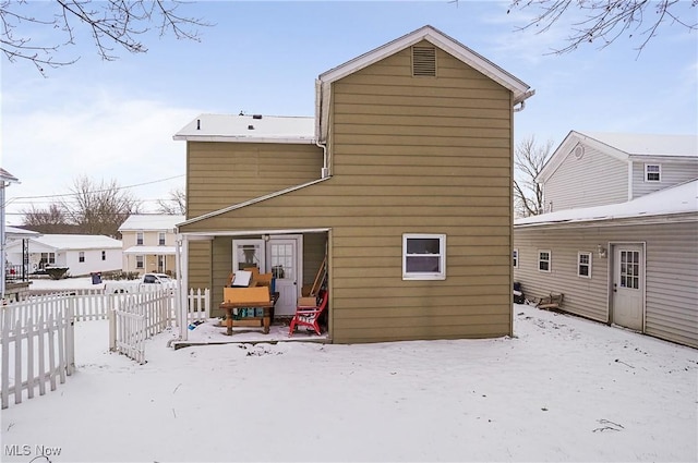 view of snow covered rear of property