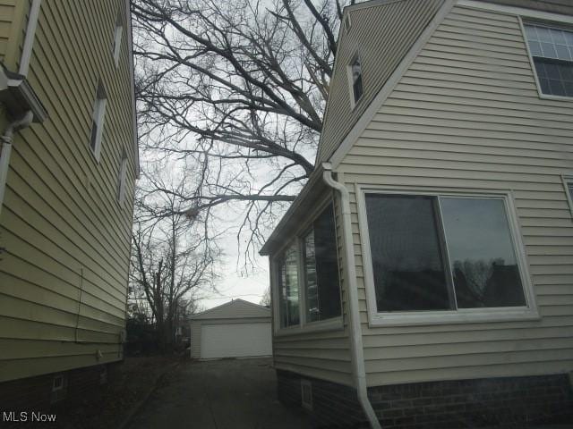 view of home's exterior with a garage and an outbuilding