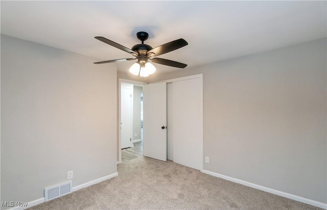 carpeted spare room with ceiling fan