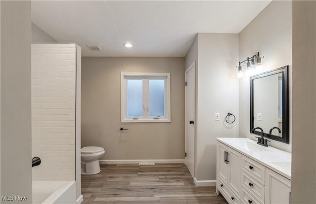 bathroom with hardwood / wood-style floors, vanity, and toilet