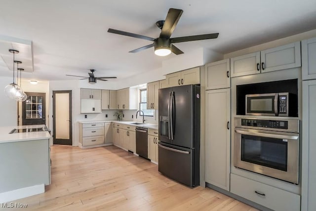 kitchen with sink, ceiling fan, stainless steel appliances, decorative light fixtures, and light wood-type flooring