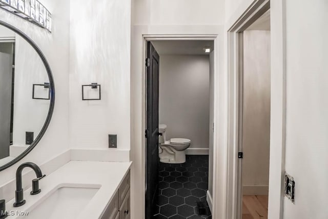 bathroom featuring vanity, tile patterned flooring, and toilet