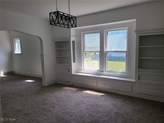 unfurnished dining area with dark carpet