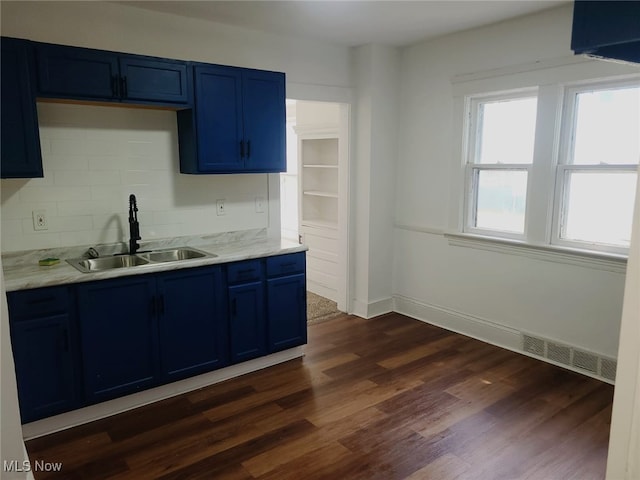 kitchen with blue cabinetry, dark hardwood / wood-style flooring, and sink