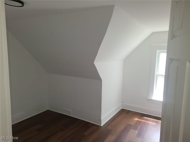 bonus room featuring dark hardwood / wood-style floors and vaulted ceiling