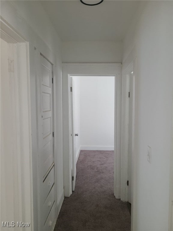 hallway featuring dark carpet