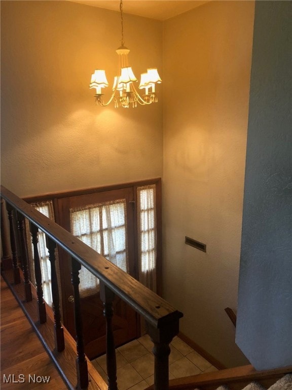 stairway with a notable chandelier