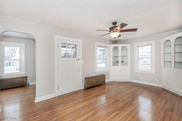 foyer featuring ceiling fan, wood-type flooring, a textured ceiling, and radiator