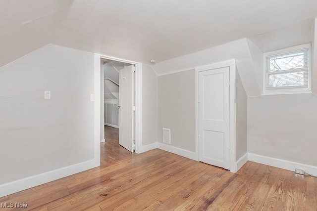 bonus room with light hardwood / wood-style flooring and lofted ceiling