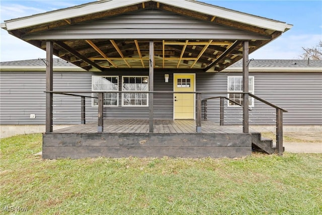 view of front facade featuring a wooden deck and a front yard