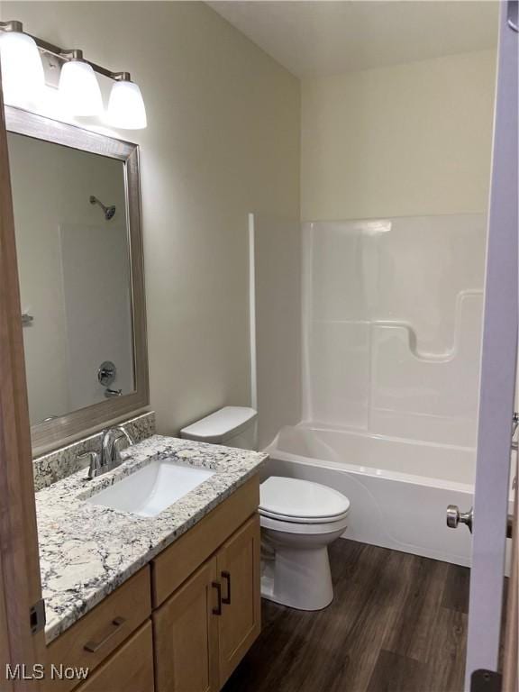 full bathroom featuring hardwood / wood-style floors, vanity, toilet, and shower / bathing tub combination