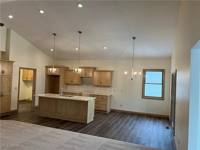 kitchen featuring decorative backsplash, a center island with sink, decorative light fixtures, and sink