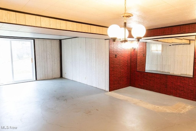 interior space featuring wood walls and a chandelier