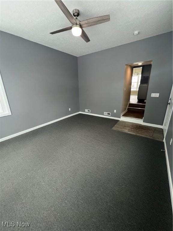 empty room featuring carpet, a textured ceiling, and ceiling fan