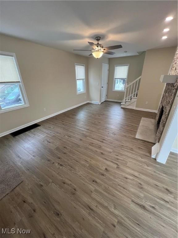 unfurnished living room featuring ceiling fan, a fireplace, and hardwood / wood-style floors